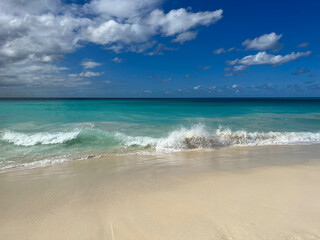 A pristine tropical Aruba beach with powdery white sand and turquoise water under a bright blue sky. Caribbean travel concept