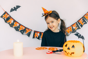 Little adorable cute Caucasian girl with curly hair playing and blowing candle with fun and...