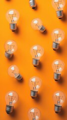 Multiple light bulbs on a yellow background in a neat pattern