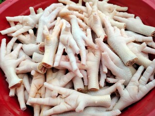 Freshly cleaned chicken feet stacked together, ready to be cooked into a variety of savory dishes....
