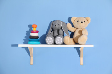 Shelf with different toys on blue background