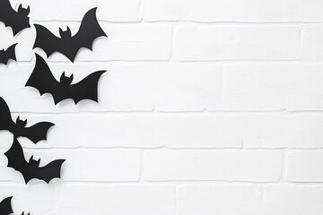 Black bats on a white brick wall background, a Halloween concept with copy space. Spooky party decoration, Minimalist design, Halloween party decorations, Scary autumn festival banner template.