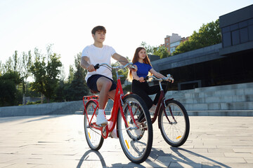Teenage girl and boy riding bicycles on city street