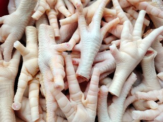 Freshly cleaned chicken feet stacked together, ready to be cooked into a variety of savory dishes....