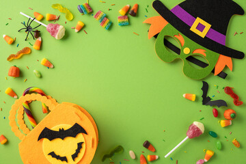 Brightly colored candy and Halloween-themed decorations arranged creatively on a vibrant green...