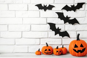 Halloween background with black bats and pumpkins on a white brick wall, Halloween decoration concept, with copy space for text, Halloween mood, mock-up template