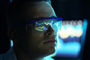 Young man wearing glasses with reflection on blurred background, closeup