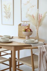 Beautiful table setting, chairs and decor in dining room. Interior design