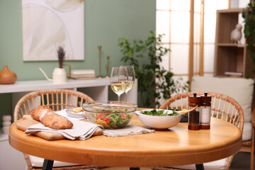 Dinner table with tasty food and white wine in stylish room