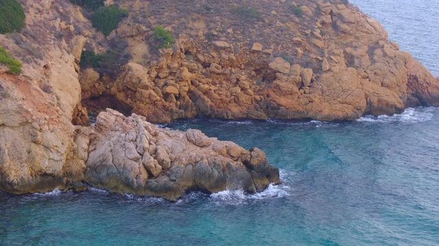 Cala Tio Ximo coastline captured in December evening light. Tranquil winter sea, soft sunset glow, peaceful view of small island near Benidorm. Quiet natural beauty, no people, only sea and sky.