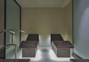 Thermal suite with heated loungers in mosaic tile design or relaxation chairs in spa or wellness area on modern luxury cruiseship or cruise ship liner in clean modern design