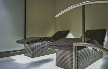 Thermal suite with heated loungers in mosaic tile design or relaxation chairs in spa or wellness area on modern luxury cruiseship or cruise ship liner in clean modern design