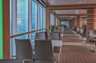 Outdoors al fresco dining tables grill area on pool deck with seating on modern cruiseship cruise ship liner with sea view