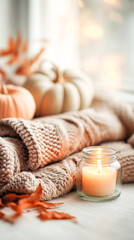 Cozy autumn scene featuring warm knitted blanket, decorative pumpkins, and a glowing candle, creating a serene and inviting atmosphere for relaxation