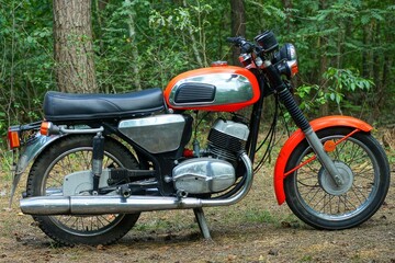 one old red chrome two wheel industrial retro heavy with black soft saddle iron industrial with round headlight motorcycle standing on ground day