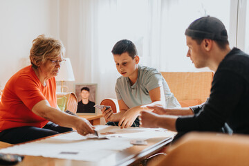 A lively moment shared by a grandmother, a teenager, and a young adult as they enjoy playing cards...