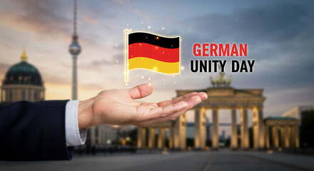 German Unity Day Concept with Hand Holding German Flag and Brandenburg Gate