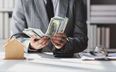 Businessman holding banknotes and counting money, savings, rent, cash flow, accounting, real...