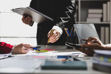 Business people analyzing financial charts and documents at office desk, analyzing financial data and company performance, discussing statistic and report. Financial planning and budget.