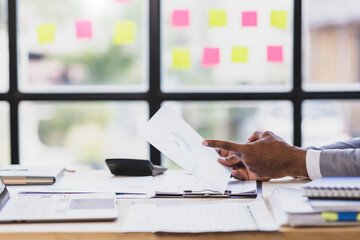 Businessman analyzing financial report with charts in office. Professional examining financial documents.