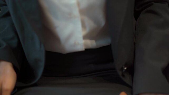 female passenger unfastening her seatbelt while seated on an airplane after landing. 