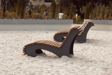 Two wooden sun loungers without people on beach