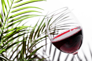 Savoring the rich hues of red wine in a delicate glass with elegant foliage backdrop