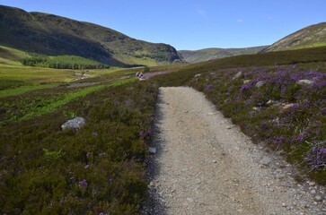 Trekkers walking into Glen Mark in the Cairngorms National Park in Aberdeenshire, Scotland, UK