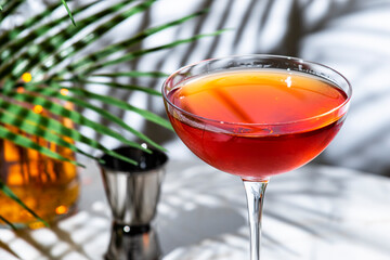 Red alcoholic cocktail with whiskey, port wine, and bitters served at a chic lounge bar setting