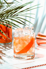 Refreshing cocktail featuring vodka aquavit, Italian aperitif, scotch whiskey, and grapefruit twist...