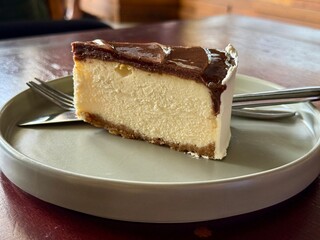 A plate of biscoff cheesecake on a wooden table in a cafe