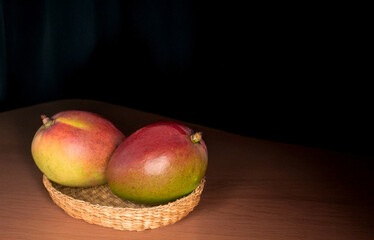 Ripe juicy mangoes on a black background, close-up.