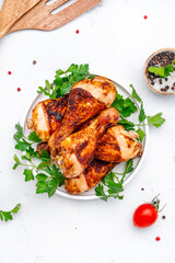 Baked chicken legs or drumsticks, white table background, top view