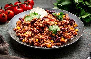 Mexican Chili dish with minced beef, beans, paprika, corn, cilantro, jalapeno pepper in tomato sauce, top view
