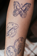 Three gothic tattoo stencil outlines — butterfly, mushroom skull, and bird skull — fully...