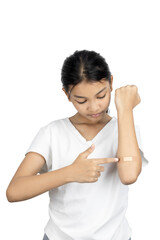 Asian girl shows a bandage on her arm after a vaccine injection. Child vaccination, healthcare, and immunization concept. isolated on white background with clipping path.