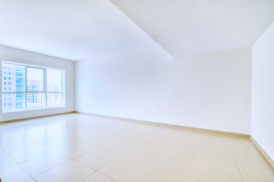 Clean unfurnished apartment interior showcasing spacious layout, raw architectural details, and abundant natural light. 