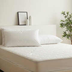 Clean white bed with pillows and a blank frame mockup on the headboard. Minimalist bedroom interior concept for comfort.