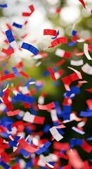 Festive confetti or shredded colored paper with motion blur. Red, blue, white colors of French or USA flag. Vertical backdrop for Bastille Day, Independence day July 4th decoration, soft focus