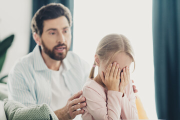 Father comforting his upset daughter during a heartfelt moment of bonding at home on a calm...