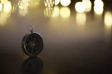 Vintage Compass with Blurred Golden Lights in Background: Guidance and Exploration Concept