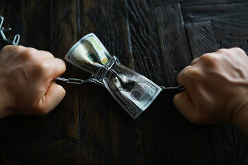 Hands Bound in Chains with Dollar Bills Symbolizing Financial Struggle
