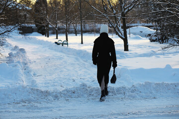 Person Walking on Snow-Covered Path in Winter Park During Sunset