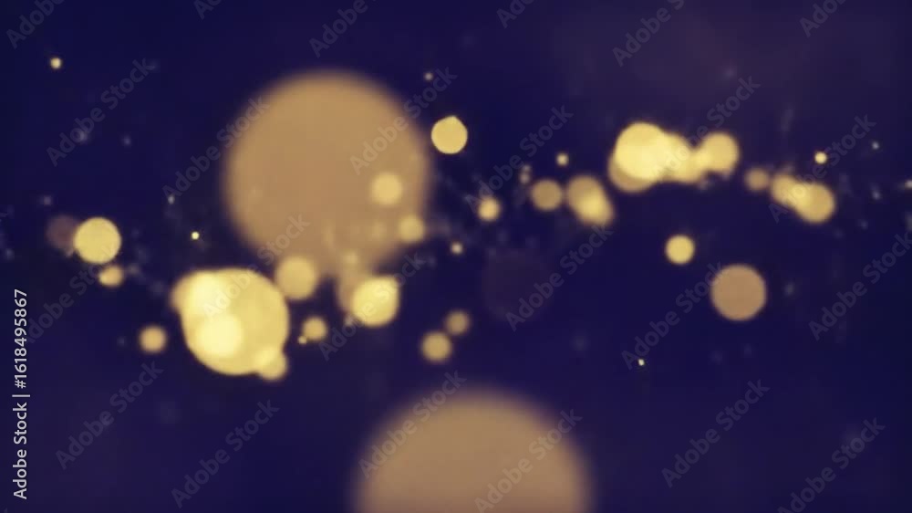 Poster loop animation of floating particles of light in golden hues moving slowly on a dark background
