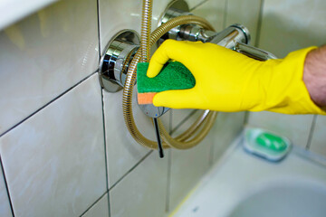 Cleaning Tap with Yellow Glove and Green Sponge