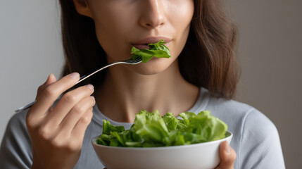 Mindful Eating Practices type. Woman eating salad with a fork, focusing on healthy eating habits.
