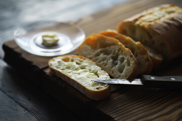 Sliced Fresh Bread with Butter on Rustic Wooden Board in Cozy Kitchen Light
