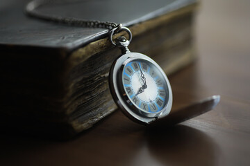 Antique Pocket Watch Resting on Old Book Close-Up with Soft Focus and Warm Lighting