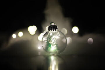 Close-Up of Illuminated Clear Christmas Ornament with Smoky Background
