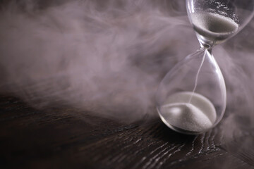Steaming Hourglass on Wooden Surface - Conceptual Image of Time and Transience